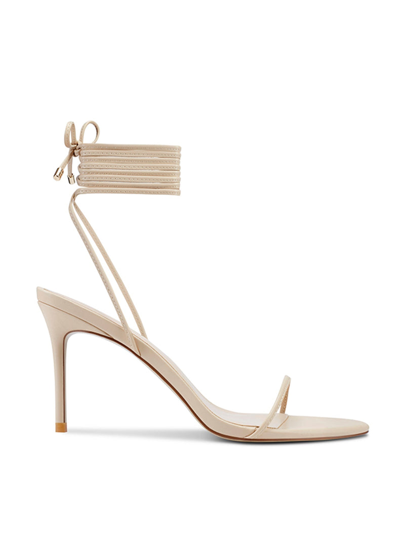 Femme LA 3.0 Barely There Lace Up in Nude – side profile showing single thin toe strap, multi-strand lace-up ankle cuff with bow, and slim stiletto heel