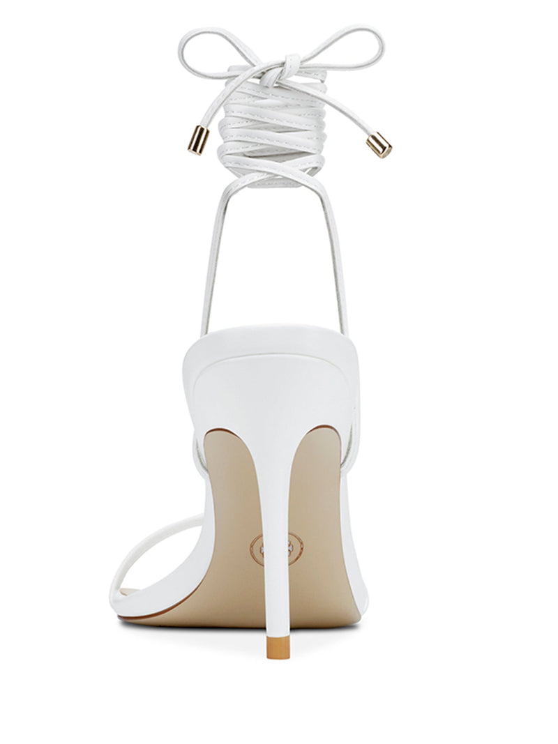 FEMME LA 3.0 Barely There Lace Up Heel in white — rear view showing slim stiletto heel and lace-up ankle tie with gold aglets