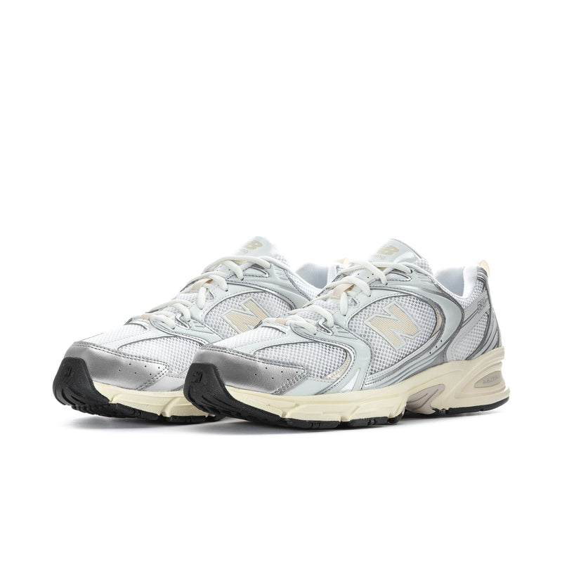 Pair of men's athletic sneakers in silver metallic and cream with black traction sole
