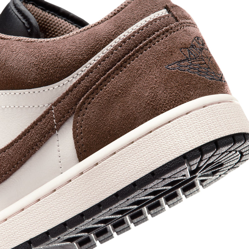 Close-up of men’s low-top sneaker side, brown suede strap and white stitching