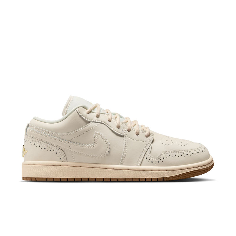 Women’s low-top sneakers in cream with gold logo and gum outsole, lace-up style.
