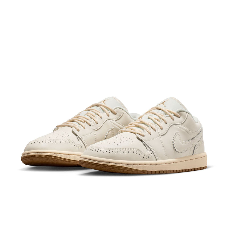 Pair of women’s cream low-top sneakers with gold accents and lace-up design, gum sole.
