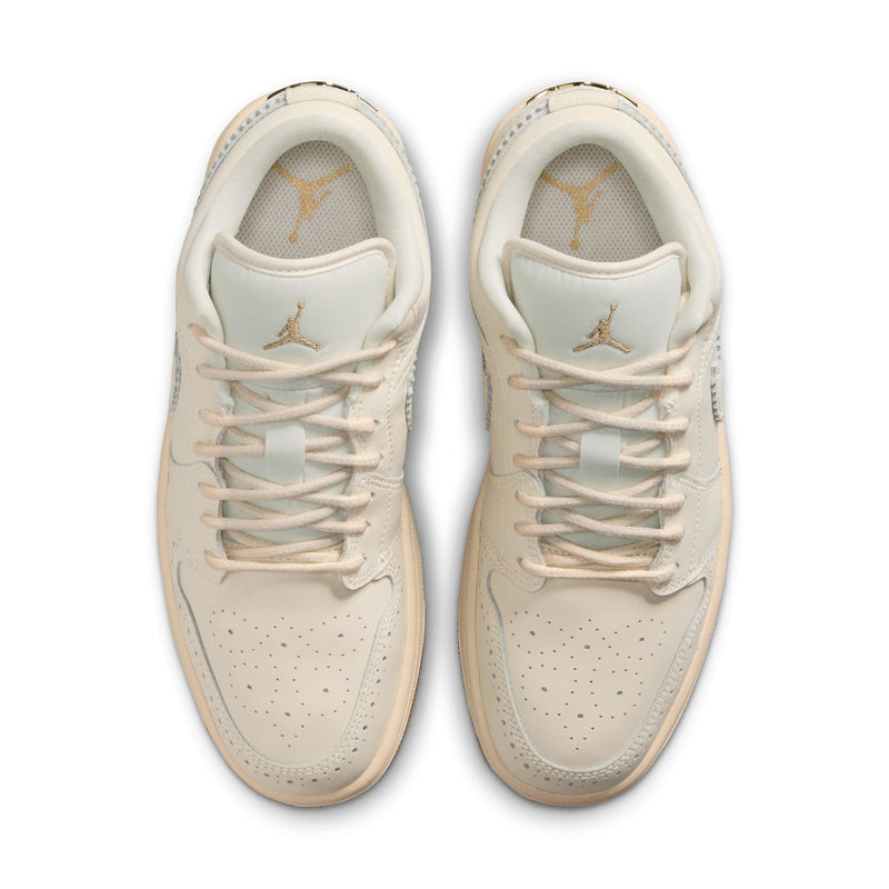 Women’s cream low-top sneaker pair, lace-up front view with subtle gold branding.