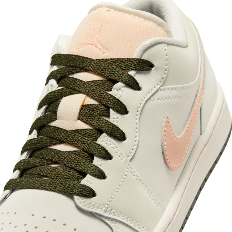 Close-up of women's low-top sneaker lace area with olive laces on off-white leather