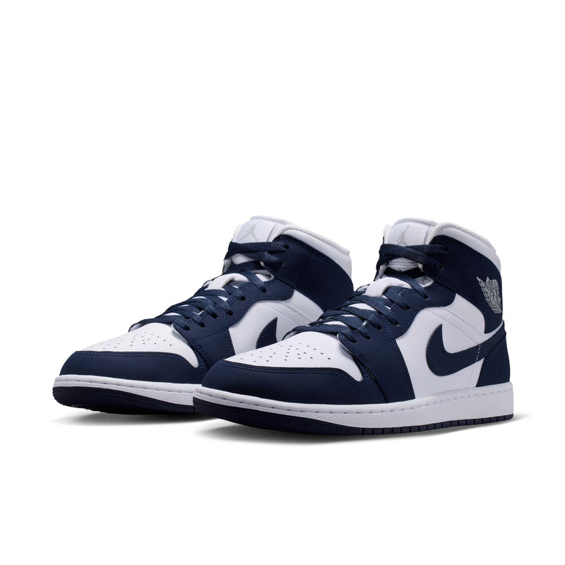 Pair of navy and white mid-top sneakers with Nike swooshes and lace-up design