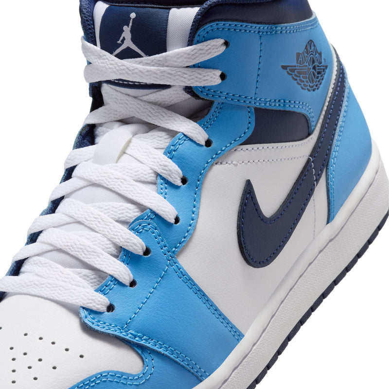 Men's mid-top sneaker close-up, white laces over blue tongue and navy swoosh