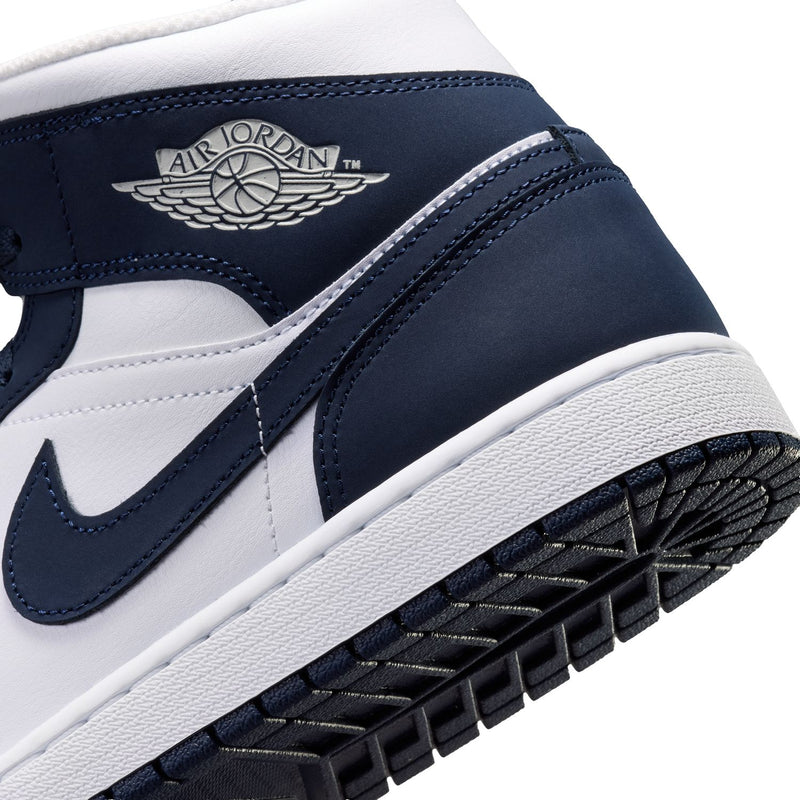 Close-up of navy and white mid-top sneaker with side swoosh and Air Jordan wings logo