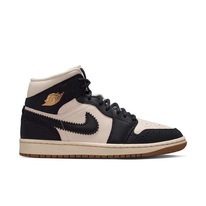 Women’s mid-top sneakers in black, off-white, and dark gum sole