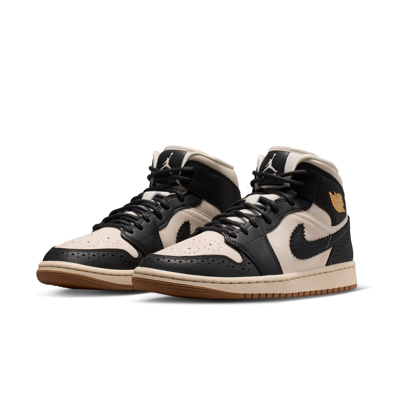 Pair of women’s mid-top sneakers with black laces, off-white panels, gum outsole