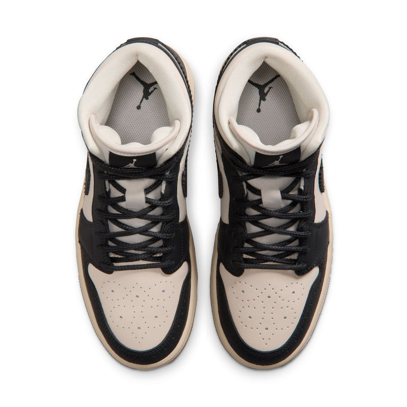 Top view of women’s mid-top sneakers, showing black laces and beige collar lining