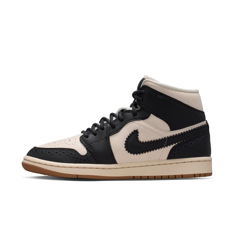 Side view of women’s mid-top sneakers in black and off-white with Air-style logo