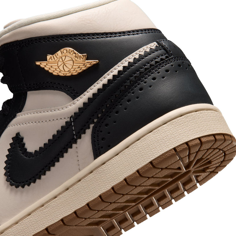 Close-up of women’s mid-top sneaker toe and side panel with perforations and stitching