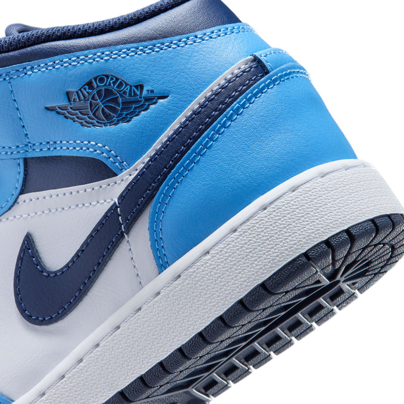 Close-up of youth mid-top sneaker side: wing logo, navy swoosh, and white midsole.
