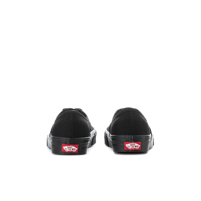 Back view of black youth sneakers with red Vans tag on heel