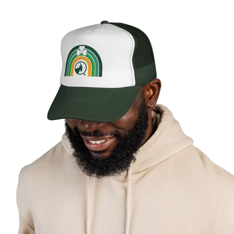 Man wearing a green and white cap with text, smiling on a white background