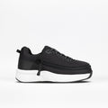 A side profile of the black Kids' Limitless sneaker by BILLY Footwear, featuring mesh fabric, black laces, and a thick white sole, is displayed against a plain white background.