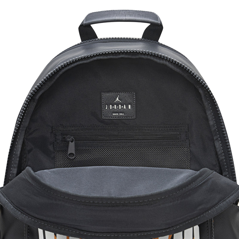 Black backpack with open top, zip pocket, and small Jordan logo patch inside.