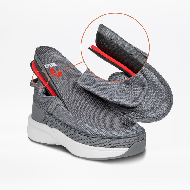 The Charcoal BILLY Limitless sneaker by BILLY Footwear features a thick white sole with an elevated upper, exposing layered details. A circular inset magnifies the red and black interior designed for adaptive kids’ shoes.