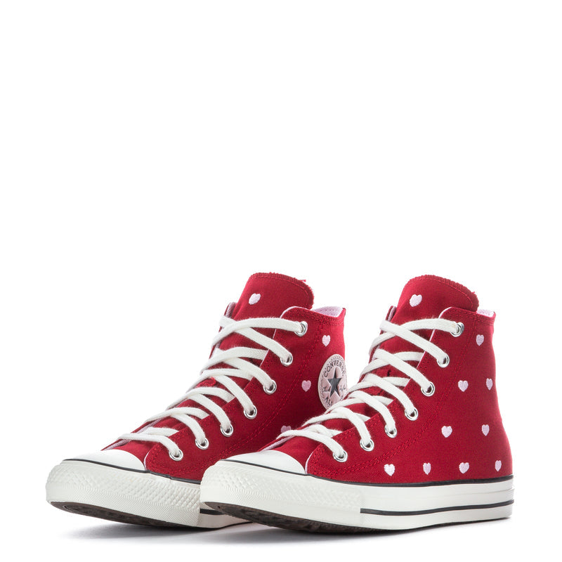 Pair of red high-top sneakers with white hearts, lace-up fronts, and rubber toe caps