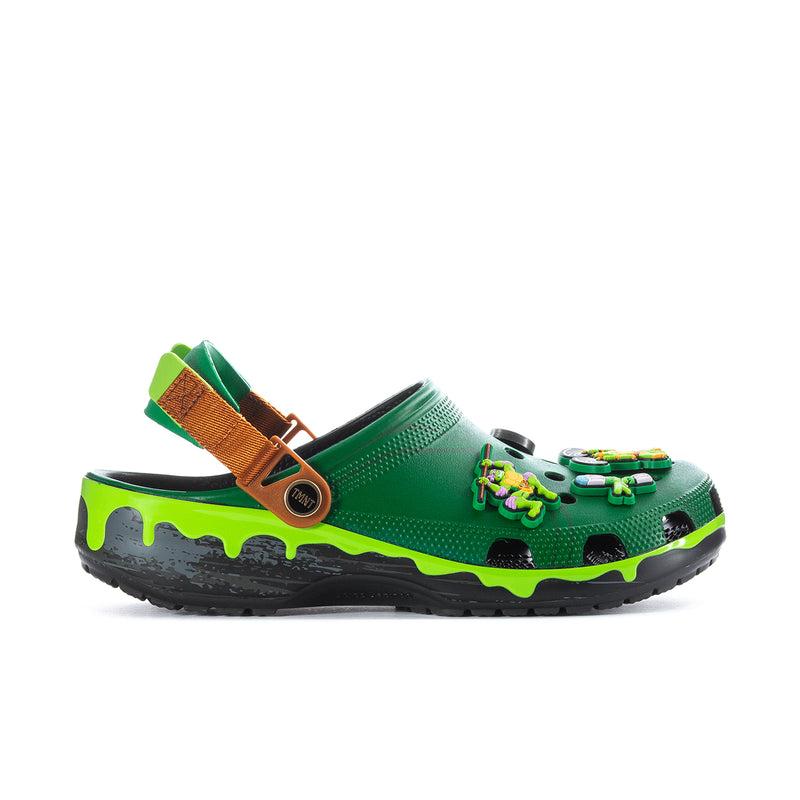 Men's green clog with brown heel strap, TMNT-style graphic accents, and textured black sole