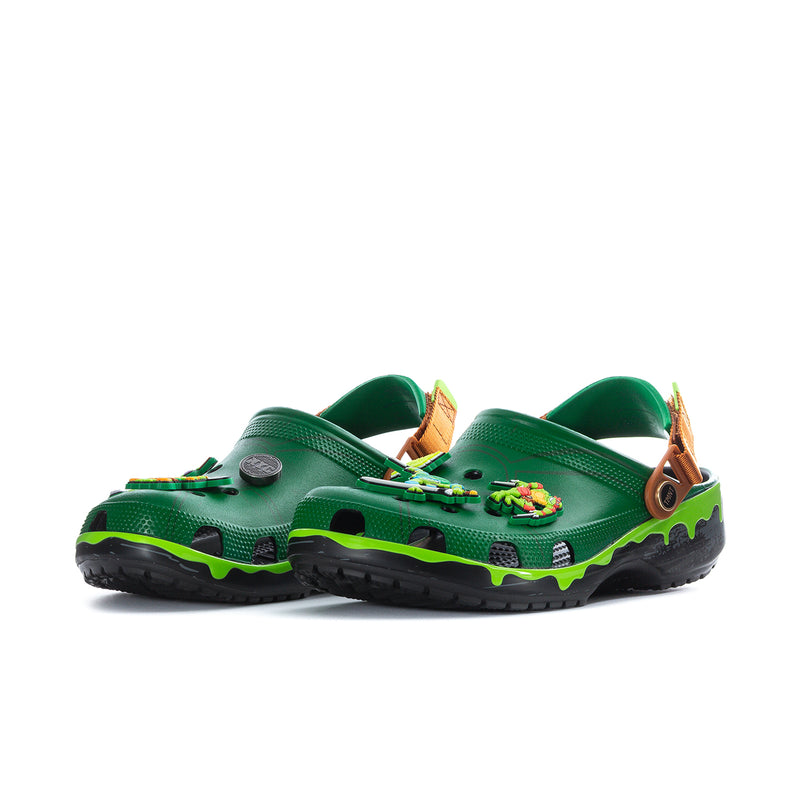 Men's green clog with side TMNT graphic and brown strap; black outsole with neon green edge
