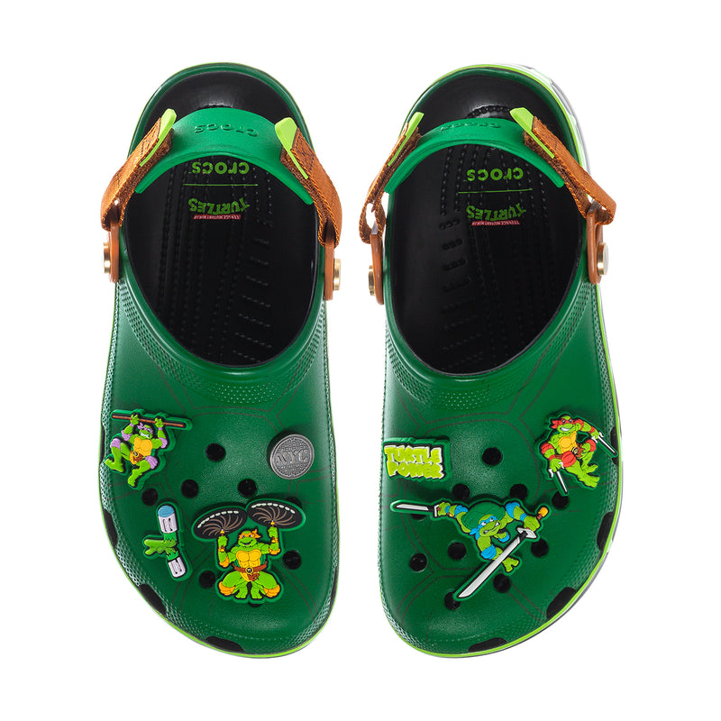 Pair of men's green clogs with openwork top, black lining, and colorful TMNT graphics