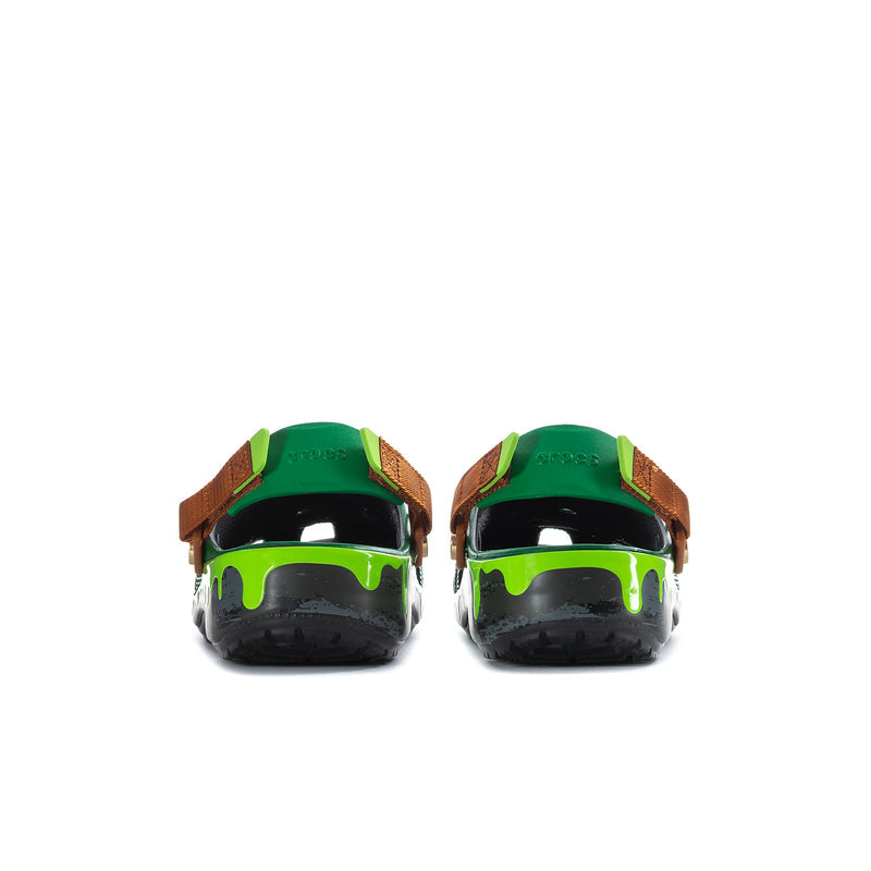 Pair of men's green clogs from back with brown straps and neon green trim on black soles