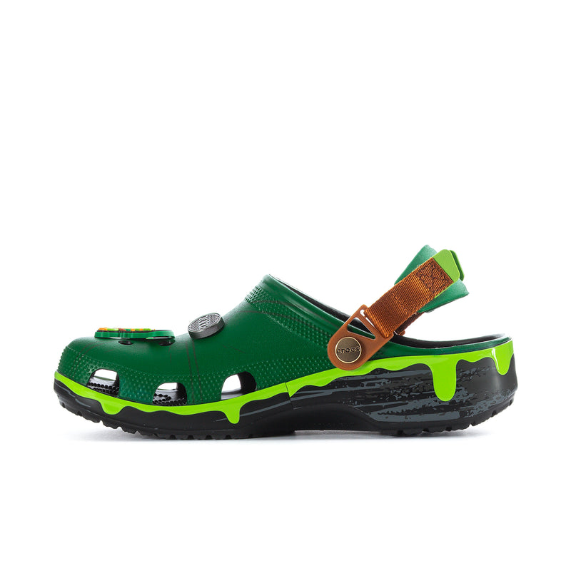 Men's green clog side profile with brown strap, round logo badge, and lime-green trim