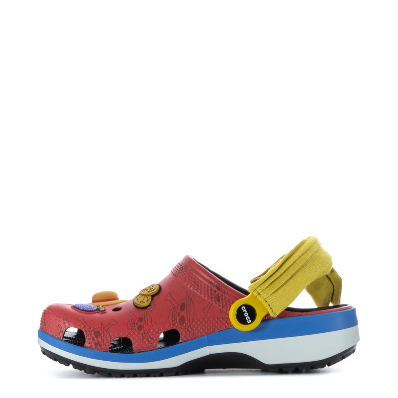 Youth clog in pink/red with blue sole and yellow strap, featuring pirate patches on side