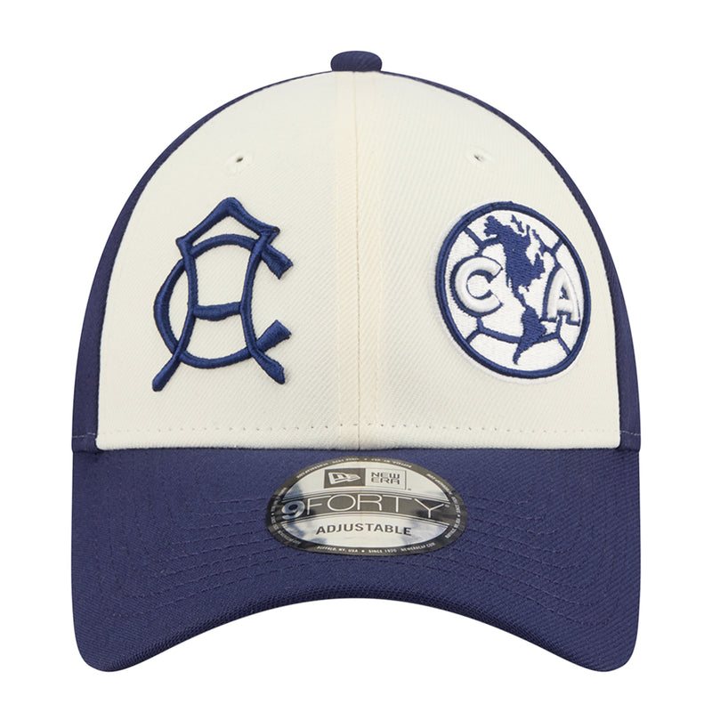 Two-tone baseball cap with white front panel, blue emblems, and adjustable strap badge