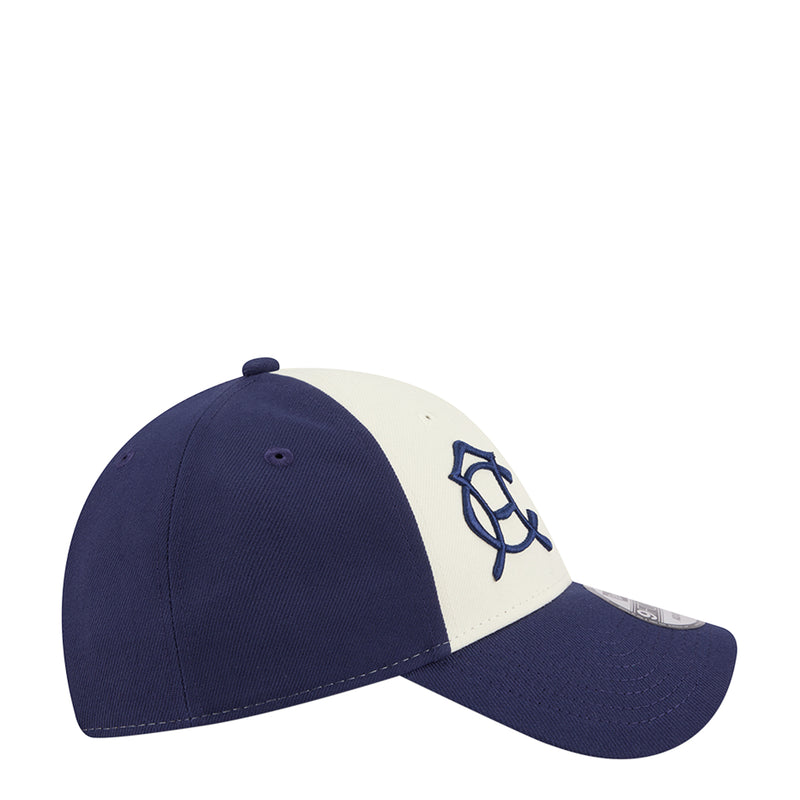 Two-tone baseball cap with navy side and white front panel featuring a blue emblem