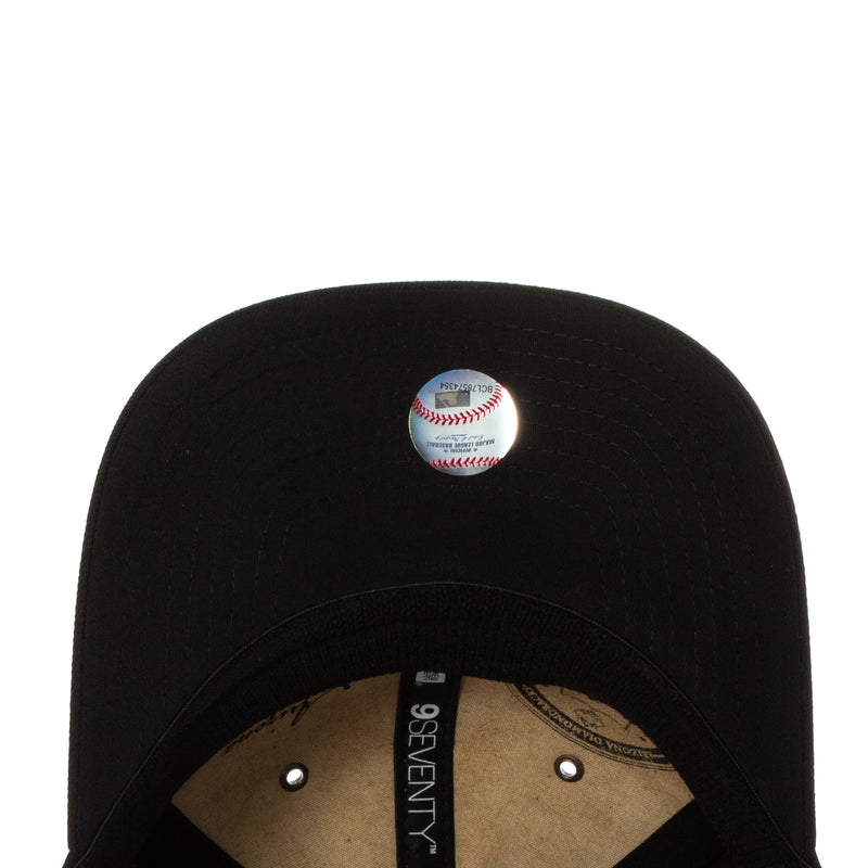 Black snapback cap crown with baseball and stitched interior label.