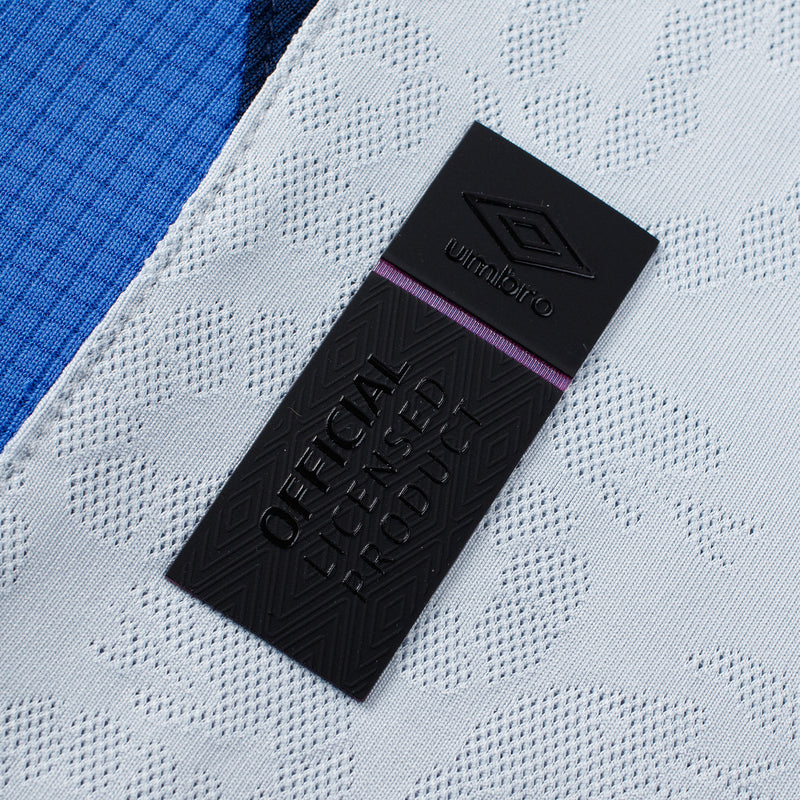 Umbro brand label tag on light grey textured jersey fabric