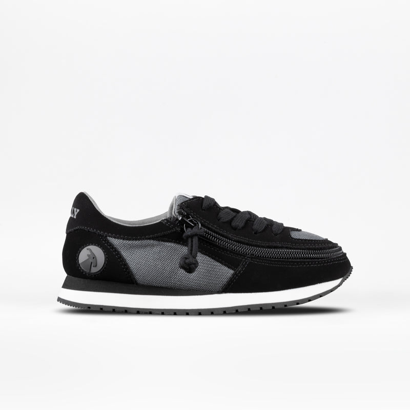 The BILLY Footwear black Kids'/Toddler Joggers are shown on a white background, paired with black and gray sneakers featuring a white sole, black laces, and a side zipper for easy access.