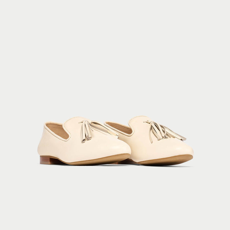 Pair of cream-colored loafers on a light gray background