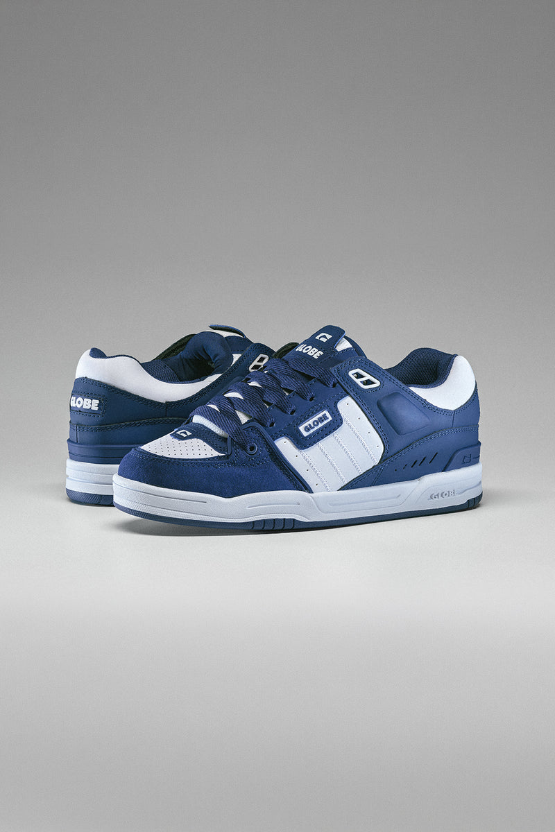 Side view of two navy Fusion skate shoes with white accents on a light gray backdrop