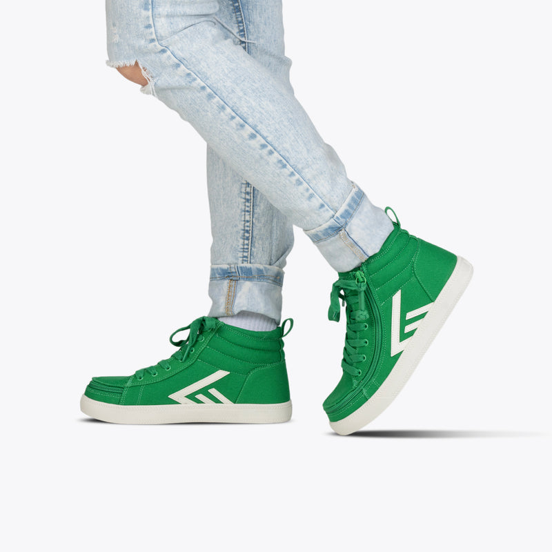A person in light blue rolled-up jeans and Green/White BILLY CS High sneakers by BILLY Footwear, featuring white soles and a white logo, stands against a plain white background.