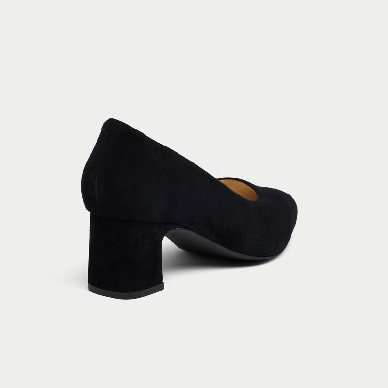 Black suede high heel shoe on a light gray background