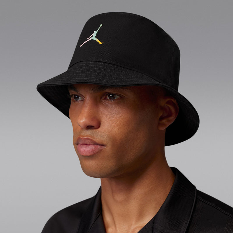 Black bucket hat with multicolor Jumpman logo, model wearing it for coverage.