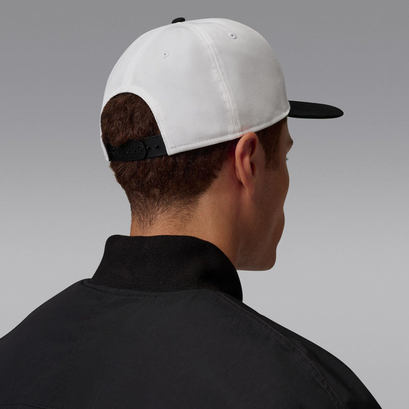 White snapback cap back view with dark adjust strap and dark underside bill