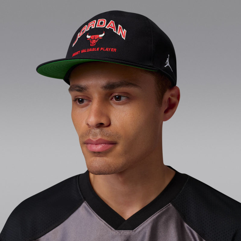 Black snapback cap with curved bill, Jordan logo patch and red lettering