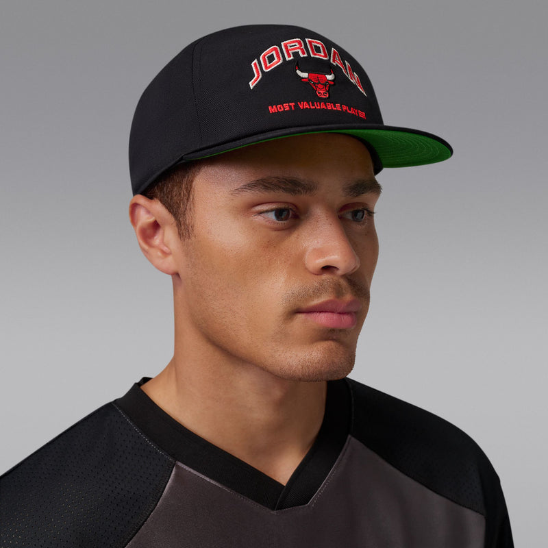 Black snapback cap with green undervisor and Jordan logo on front