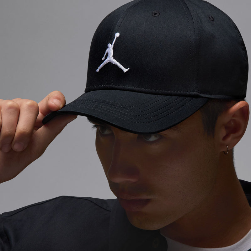Black Jordan Rise cap with white Jumpman logo and curved bill, angled view