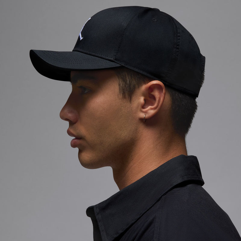 Black Jordan Rise cap with white Jumpman logo and curved bill, side profile