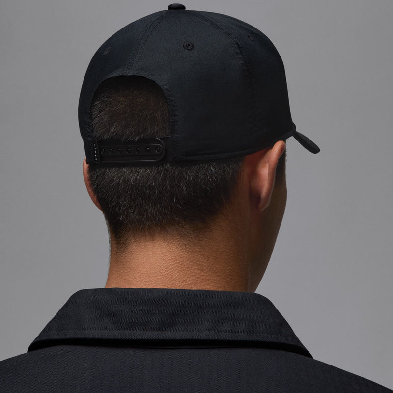 Black snapback cap back view with adjustable strap and small top button