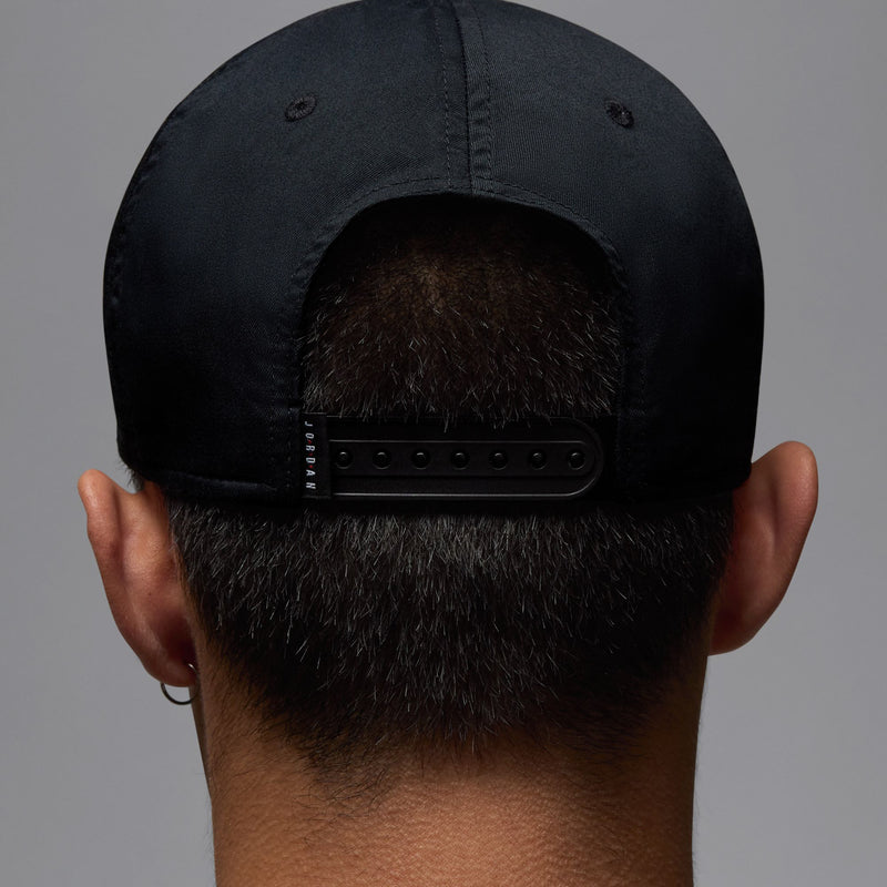 Black structured snapback cap with curved bill and adjustable back strap