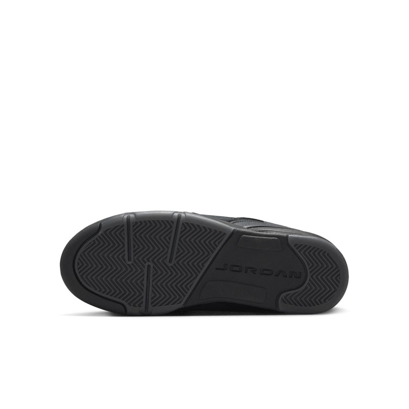 Black rubber outsole of youth low-top sneakers with textured tread pattern