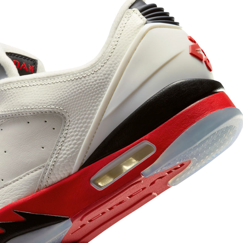Close-up of men's white leather sneaker with red midsole and black lace eyelets