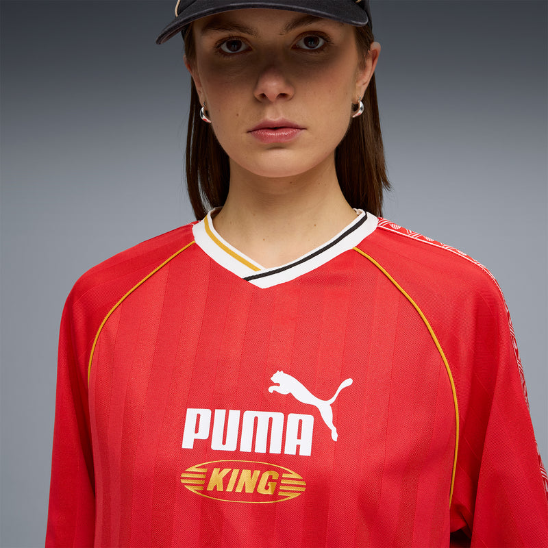 Red jersey close-up with Puma King graphic, yellow piping, and white V-neck
