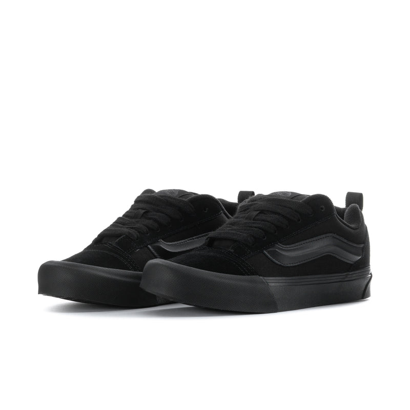 Men's black low-top skate shoes, angled side view, chunky rubber cupsole